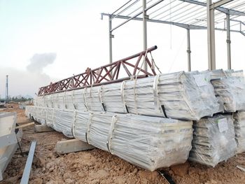 Stack of metallic structure on field against sky