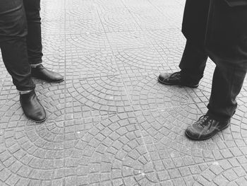 Low section of people standing on cobblestone