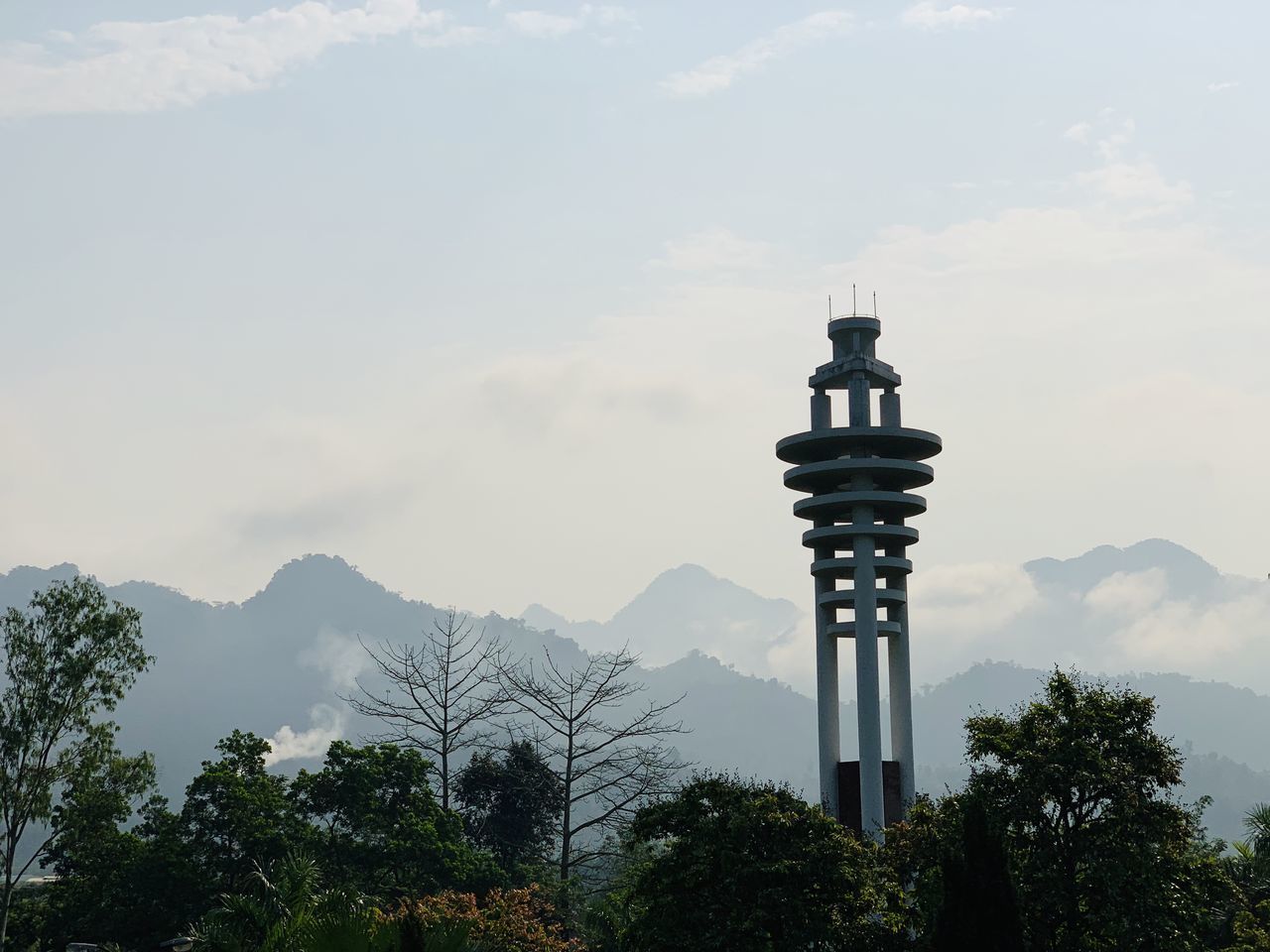 LOW ANGLE VIEW OF TOWER ON MOUNTAIN AGAINST CLOUDY SKY