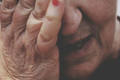 Close-up of woman covering face with hand