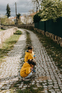 Rear view of woman walking on footpath