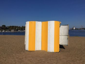 Close-up of beach against clear blue sky