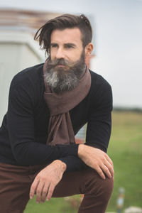 Close-up of hipster on field against sky