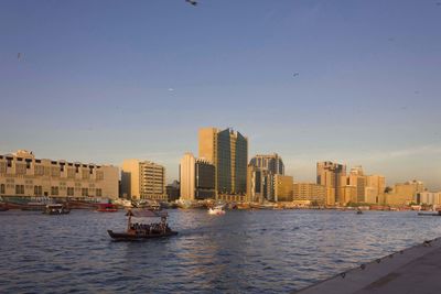 View of sea and buildings against clear sky