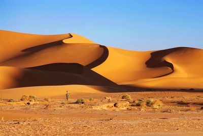 Scenic view of desert against clear blue sky