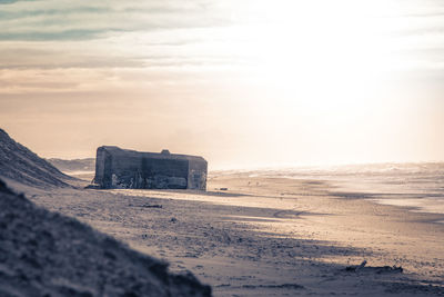 Bunker at sandy beach against sky