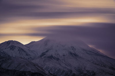 Scenic view of snowcapped mountains against sky during sunset