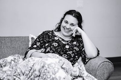 Portrait of woman sitting on sofa at home