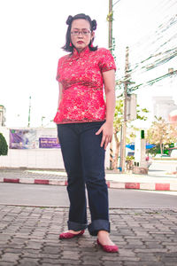 Portrait of young woman standing on street