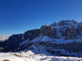 Scenic view of snowcapped mountains against clear blue sky