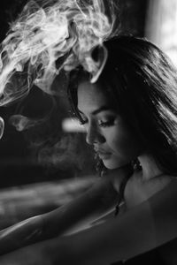 Close-up portrait of young woman smoking