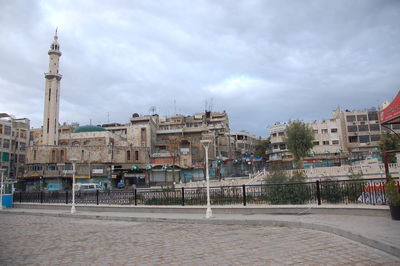 Buildings in city against cloudy sky