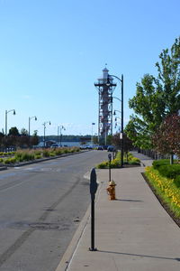 Man walking on road in city against clear sky