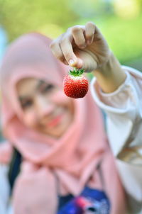 Midsection of woman holding strawberry
