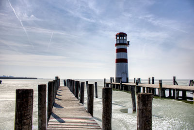 Lighthouse on beach against sky