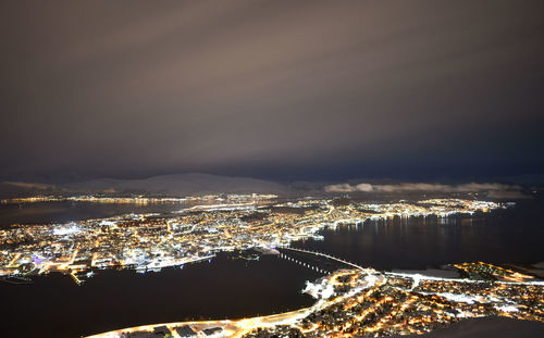 High angle view of illuminated buildings against sky at night