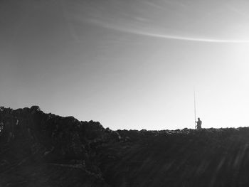 Man on landscape against clear sky