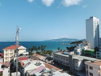 High angle view of buildings by sea against sky