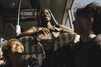 Happy multiracial lgbtqia friends in bus on sunny day