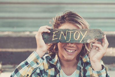 Portrait of smiling girl holding text