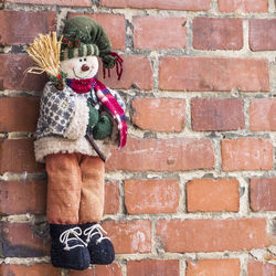 Close-up of child on brick wall