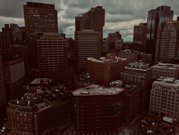 High angle view of modern buildings against cloudy sky in city during sunset