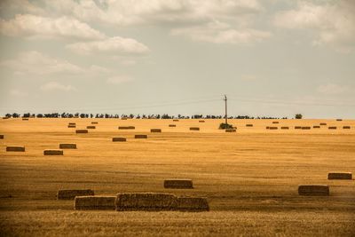 View of field against cloudy sky