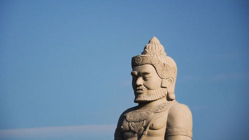 Low angle view of statue against blue sky