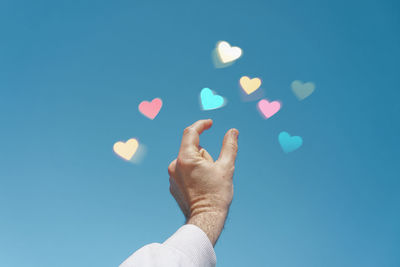 Hand up in the sky touching a heart shape, love emotions in valentine's day