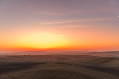 Scenic view of desert against sky during sunset