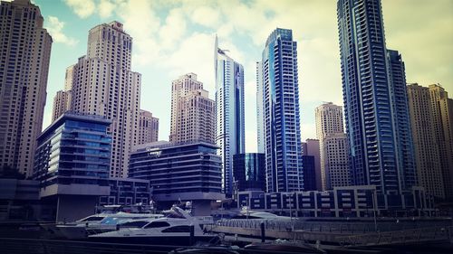 Buildings in city against cloudy sky