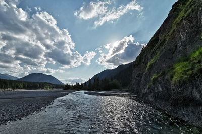 Scenic view of river isar by mountains against sky in bavarian alps
