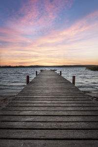 Pier over sea against sky during sunset