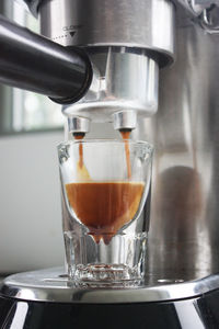 Close-up of pouring coffee in glass at cafe