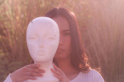 Portrait of woman holding statue