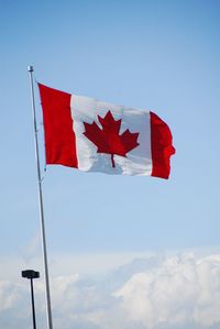 Low angle view of flag against blue sky