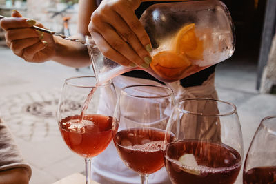 Midsection of woman pouring drinks in wineglass