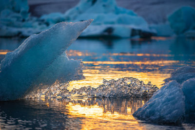 Scenic view of icebergs on lake during sunset