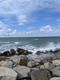 Rocks on sea shore against sky