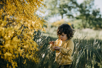 Boy standing by plants