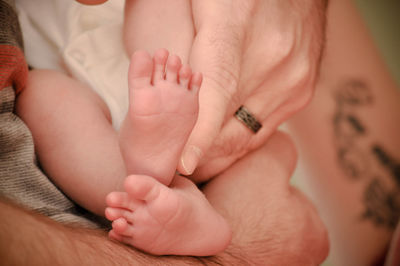 Close-up of person finger touching baby leg