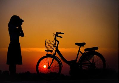 Sunset mountain peak woman photographing bicycle