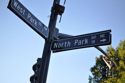 Low angle view of street name sign against clear sky