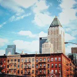 Low angle view of modern building against cloudy sky