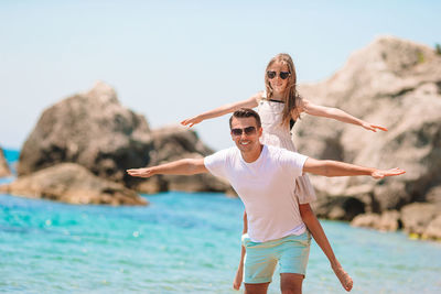 Father piggybacking daughter at beach