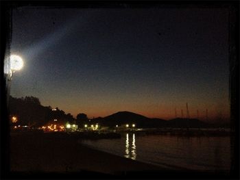 Scenic view of lake against sky at night