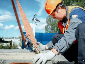 Side view of young man working at beach