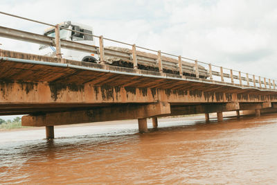 Low angle view of bridge over river against sky