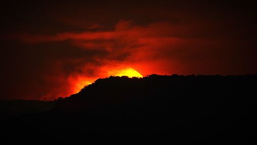 Scenic view of silhouette mountain against sky at sunset