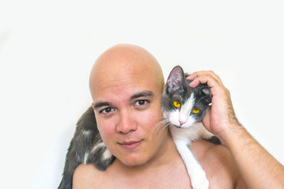 Portrait of man with cat against white background